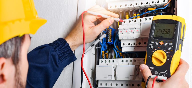 multimeter in hands of electricians detail.