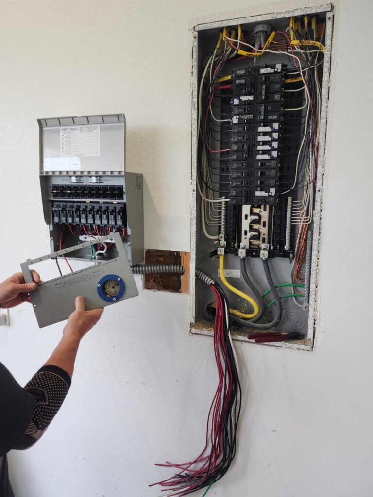 Burning smell from an outlet or electrical panel — Northwest Arkansas electrician inspecting breaker box during residential wiring repair